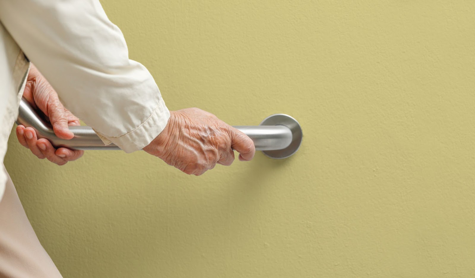 n older woman's hands use a grab bar for balance support